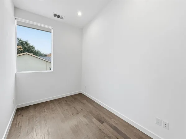 a view of a small space with wooden floor and a window