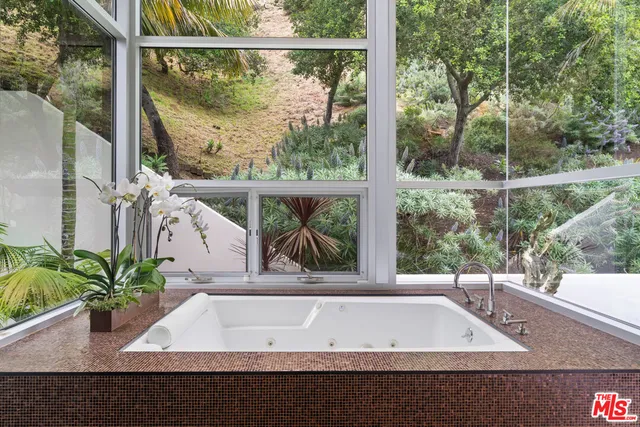 a bathroom with a double vanity sink a mirror and a bathtub
