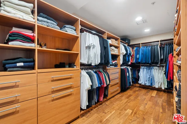 a bedroom with a large bed and a flat tv screen on dresser