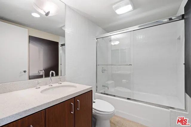 a bathroom with a double vanity sink toilet mirror and shower