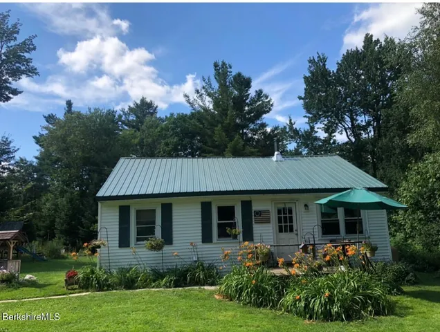 a view of a house with garden and a tree