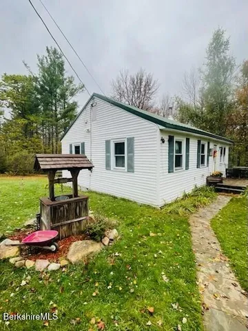 a view of a house with backyard sitting area and garden