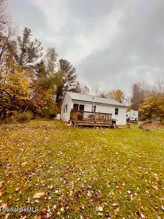 a front view of a house with a big yard and large trees