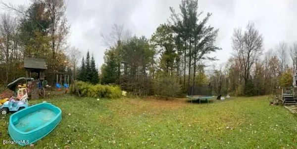 a backyard of a house with yard and trampoline