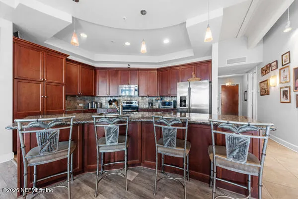 a kitchen with stainless steel appliances granite countertop a stove top oven a sink dishwasher a dining table and chairs