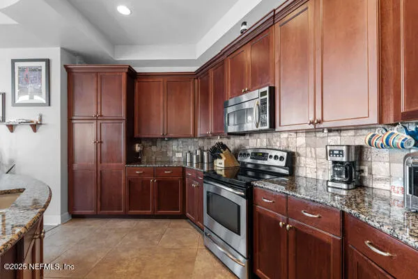 a kitchen with stainless steel appliances granite countertop a stove a sink dishwasher and a refrigerator
