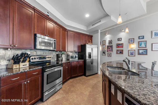 a kitchen with stainless steel appliances granite countertop a stove refrigerator sink and cabinets