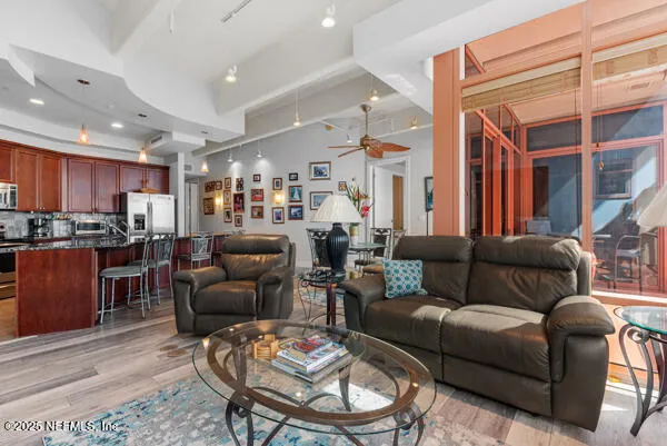a living room with furniture kitchen and a wooden floor