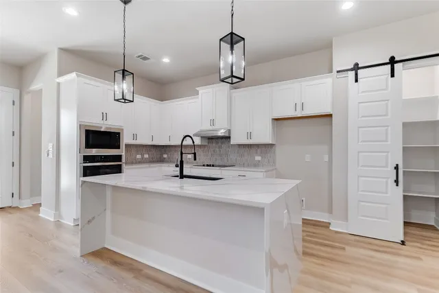a kitchen with kitchen island a counter space a sink and appliances