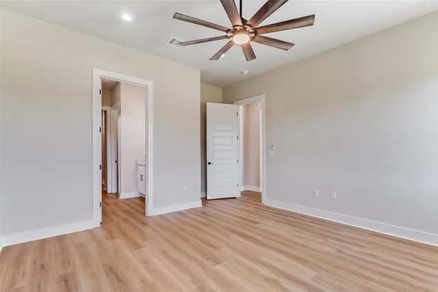 an empty room with wooden floor and closet