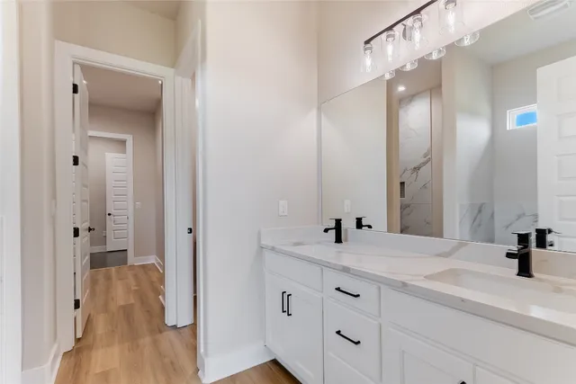 a bathroom with a double vanity sink mirror and shower
