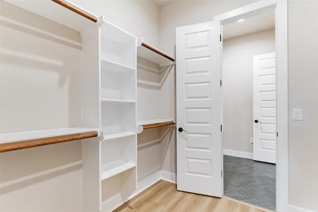 a view of walk in closet with empty racks