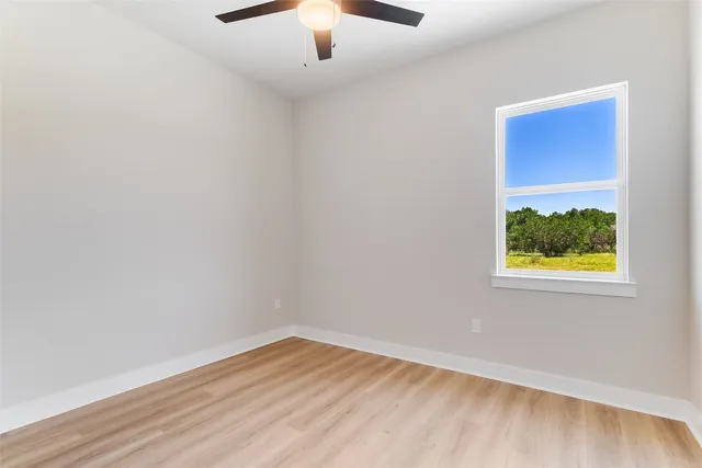 an empty room with a window and wooden floor