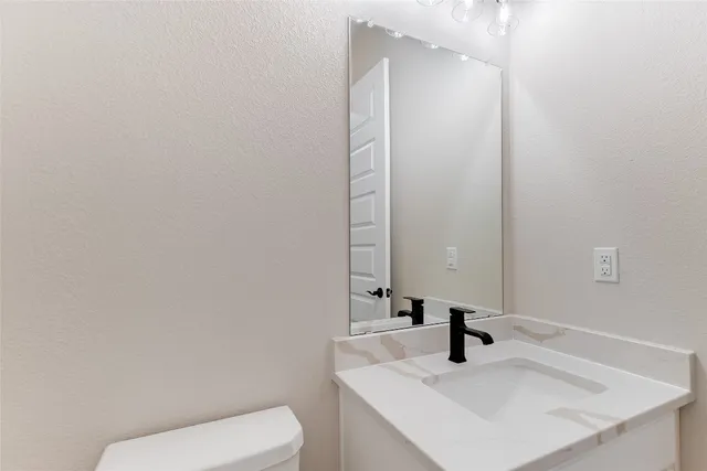 a bathroom with a sink a toilet and mirror
