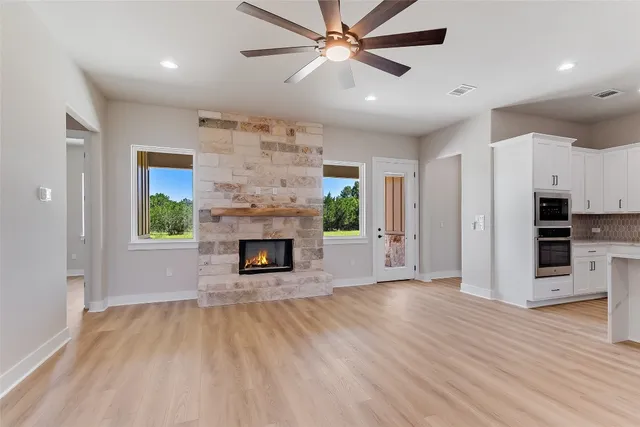 an empty room with kitchen and a fireplace