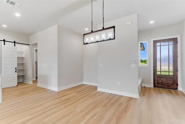a view of empty room with wooden floor and window
