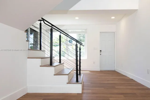 a view of a big room with wooden floor and windows