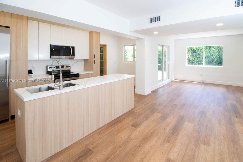 1255 Jackson Street Hollywood, FL 33019 - Photo 25 of 72 a large white kitchen with wooden floor and a sink