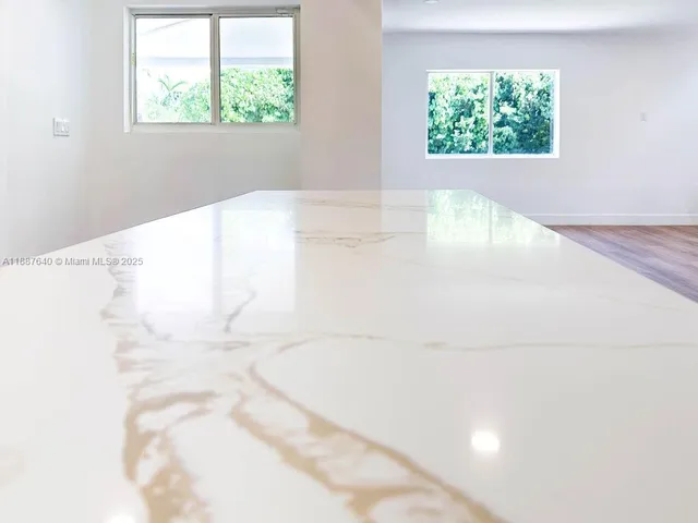 a view of a room with wooden floor and a window