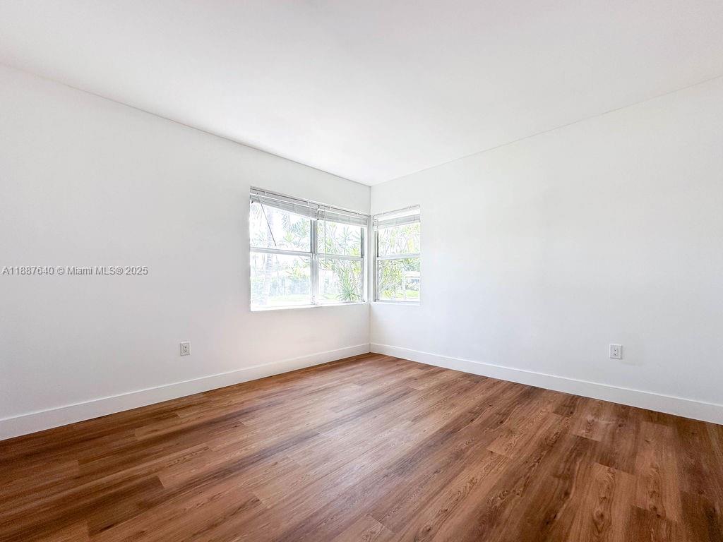 1255 Jackson Street Hollywood, FL 33019 - Photo 33 of 72 an empty room with wooden floor and windows