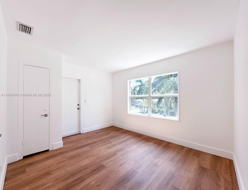 1255 Jackson Street Hollywood, FL 33019 - Photo 37 of 72 an empty room with wooden floor and windows