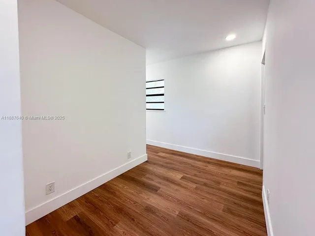 a view of a room with wooden floor and white walls