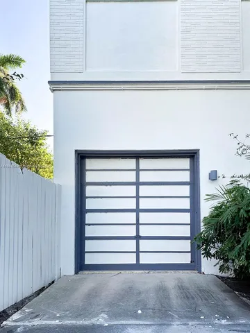 a view of a fountain in front of a house with a palm tree
