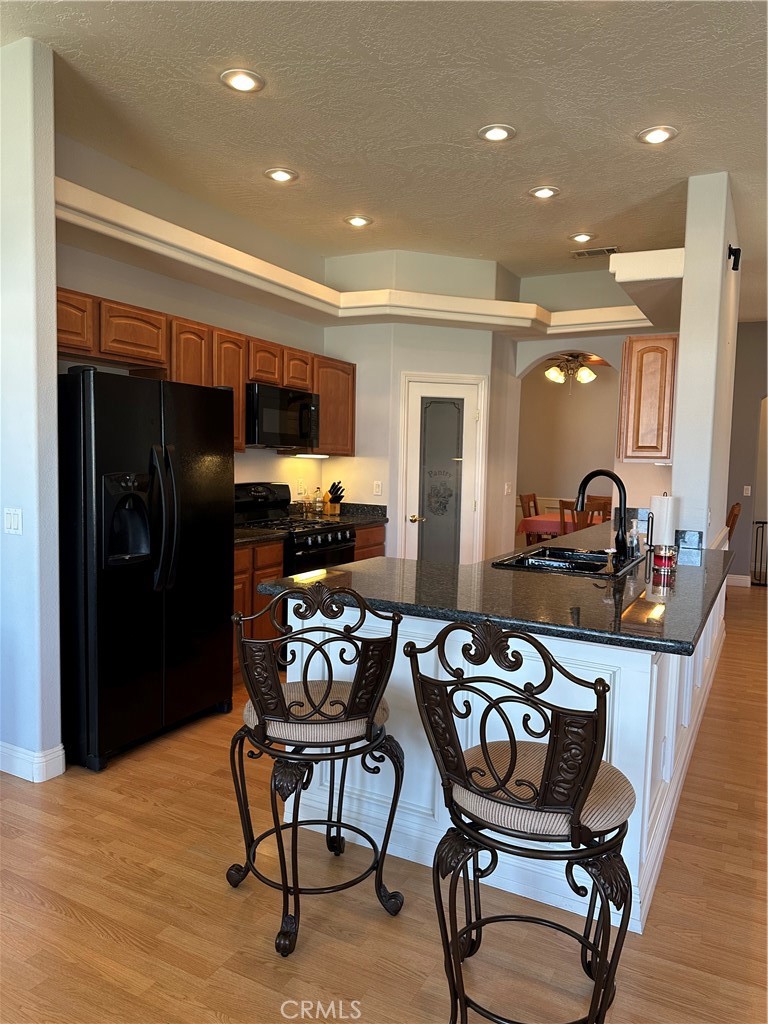 14108 Rivers Edge Road Helendale, CA 92342 - Photo 11 of 37 a kitchen with stainless steel appliances kitchen island granite countertop a dining table chairs refrigerator and sink
