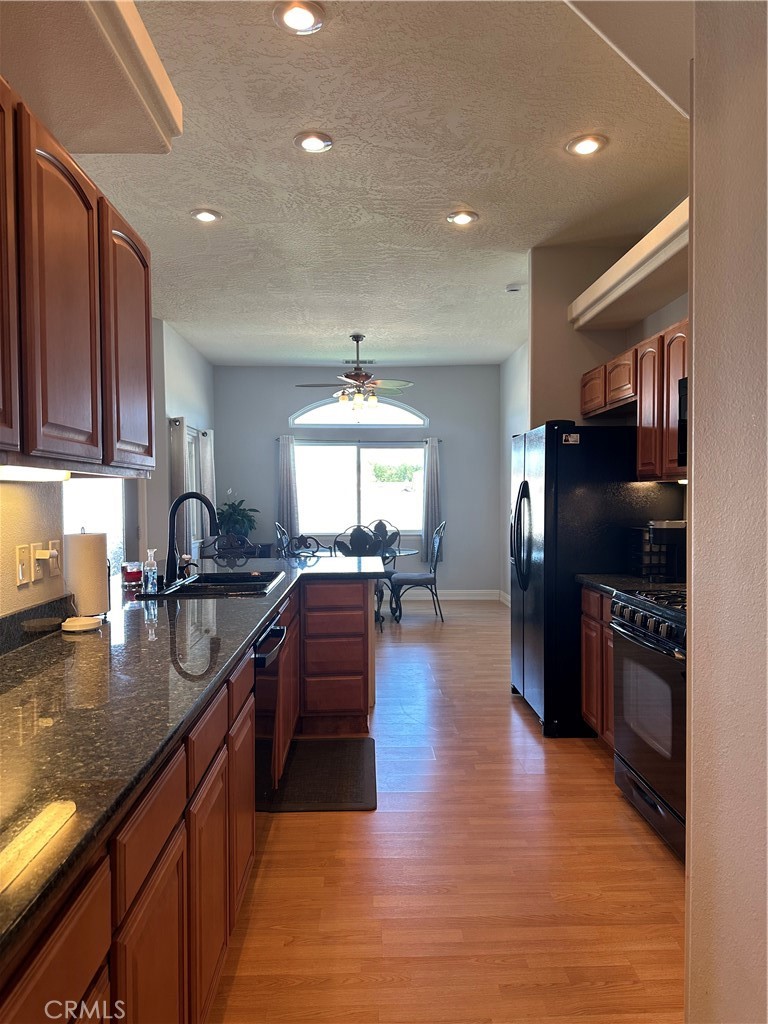 14108 Rivers Edge Road Helendale, CA 92342 - Photo 9 of 37 a kitchen with granite countertop stainless steel appliances and wooden cabinets