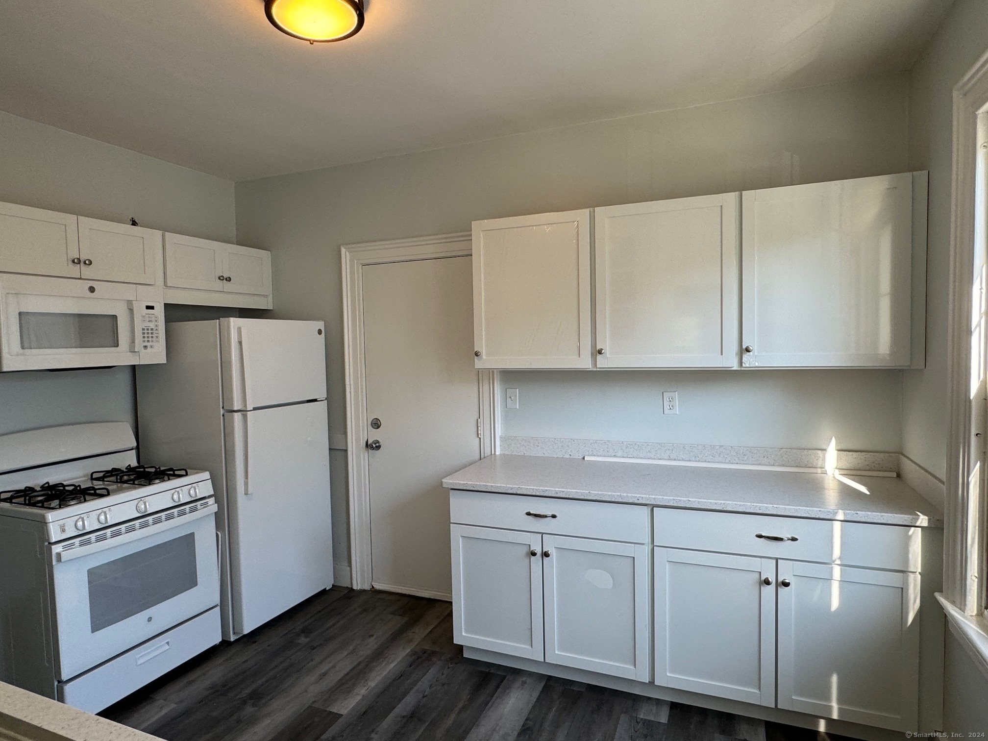 1253 Forest Road, Unit 2 New Haven, CT 06515 - Photo 19 of 30 a kitchen with white cabinets and white appliances