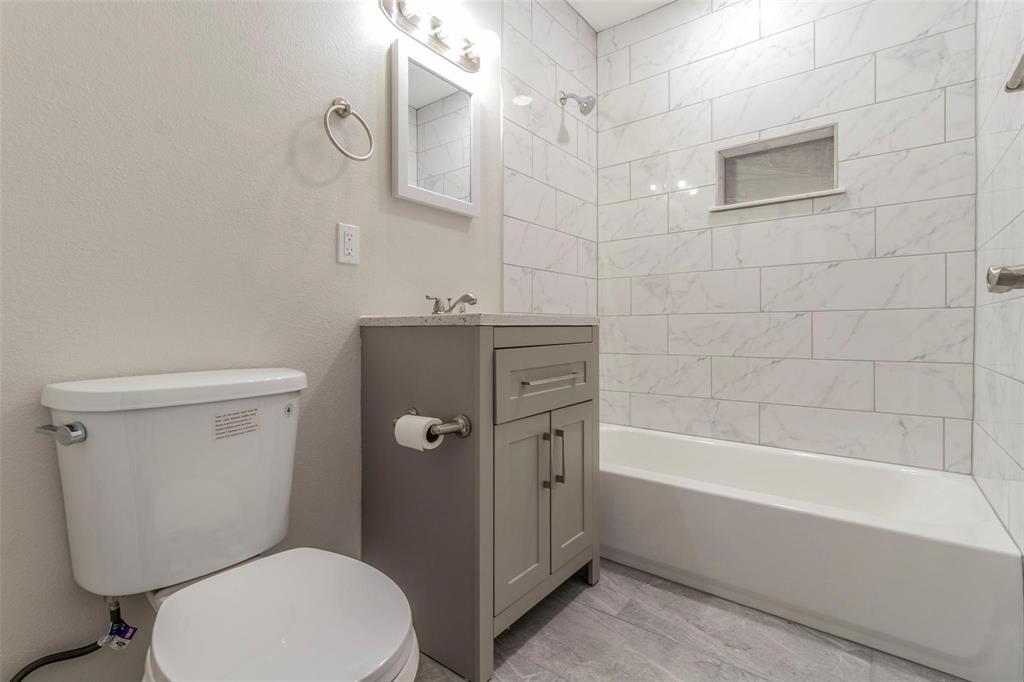 4714 Old Benbrook Road Fort Worth, TX 76116 - Photo 6 of 15 a bathroom with a granite countertop toilet a sink and bathtub
