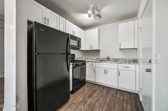 a kitchen with stainless steel appliances a refrigerator sink and cabinets