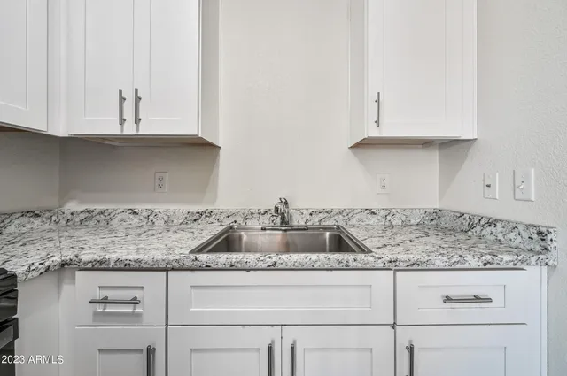 a kitchen with white cabinets and a sink