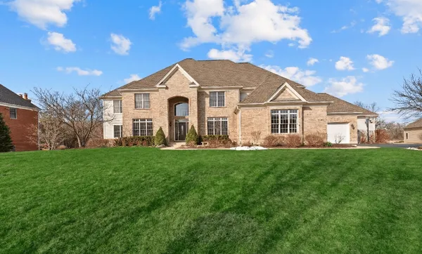 a view of house with a big yard and large trees