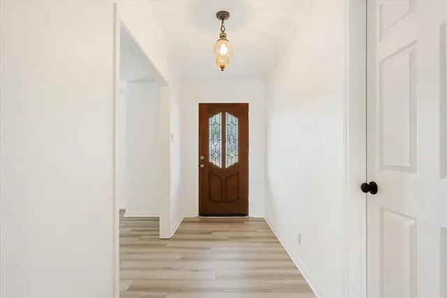 a view of a hallway with wooden floor and entryway