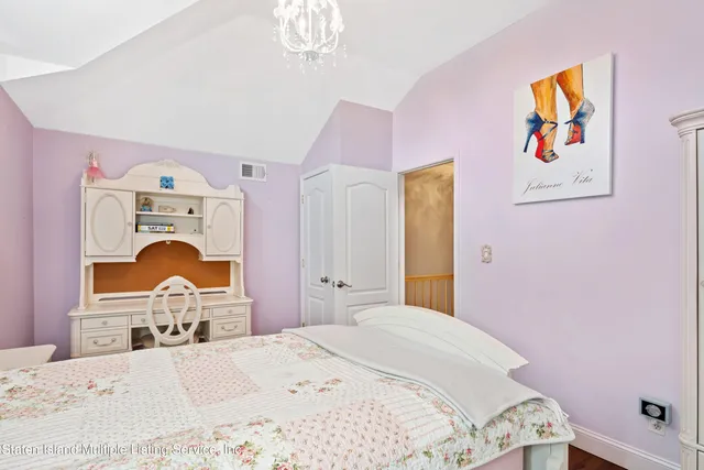 a bedroom with a bed and a painting on the wall