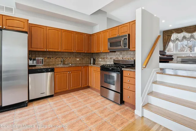 a kitchen with stainless steel appliances granite countertop a stove top oven a sink and dishwasher