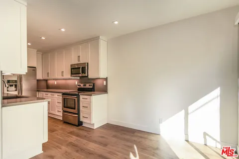 a kitchen with stainless steel appliances granite countertop a stove a sink and a refrigerator