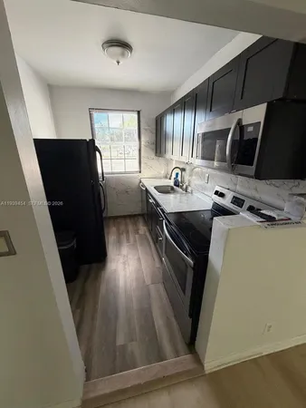 a kitchen with sink cabinets and wooden floor