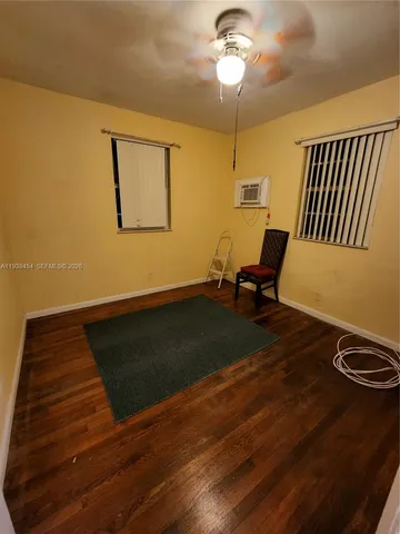 a living room with wooden floor furniture and a window
