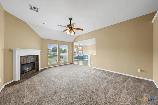 a view of an empty room with a fireplace and a window