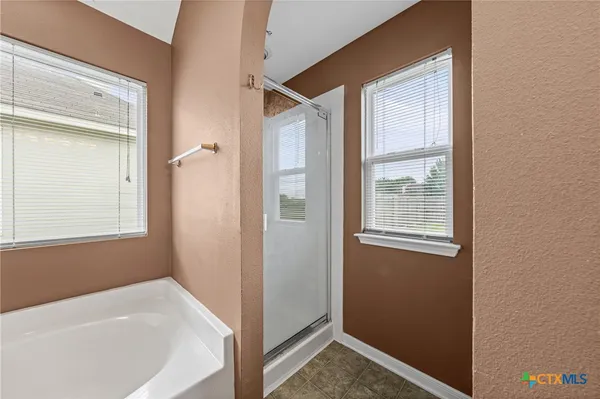 a spacious bathroom with a granite countertop sink a mirror and a bathtub