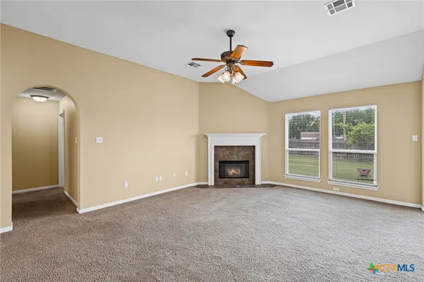 a bed sitting in a spacious bedroom next to a window