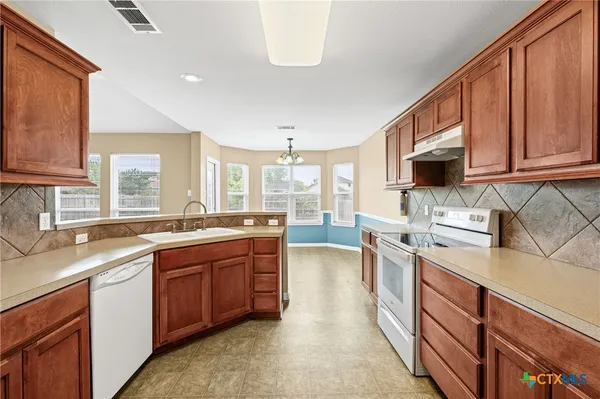 a kitchen with a sink stove and cabinets