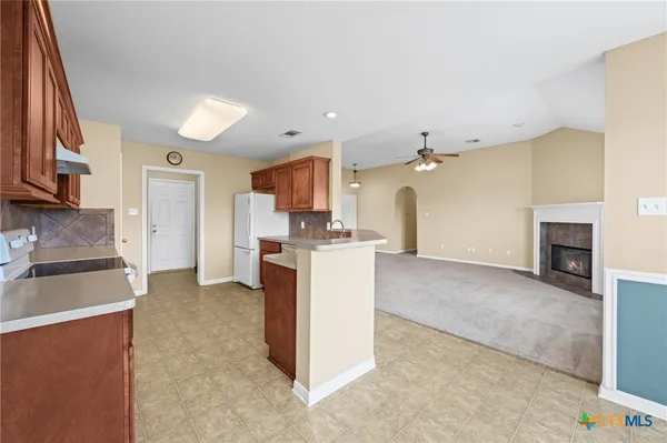 a kitchen with a refrigerator and a stove top oven