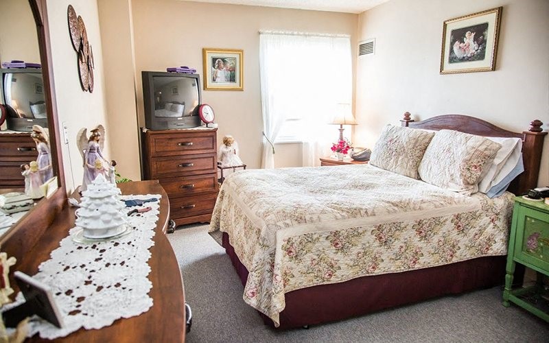 404 St Louis Avenue Excelsior Springs, MO 64024 - Photo 11 of 12 a bed sitting in a bedroom next to a window with dresser