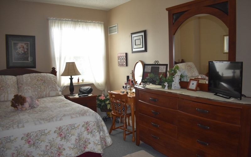 404 St Louis Avenue Excelsior Springs, MO 64024 - Photo 12 of 12 a bedroom with a large bed and a flat tv screen on the dresser