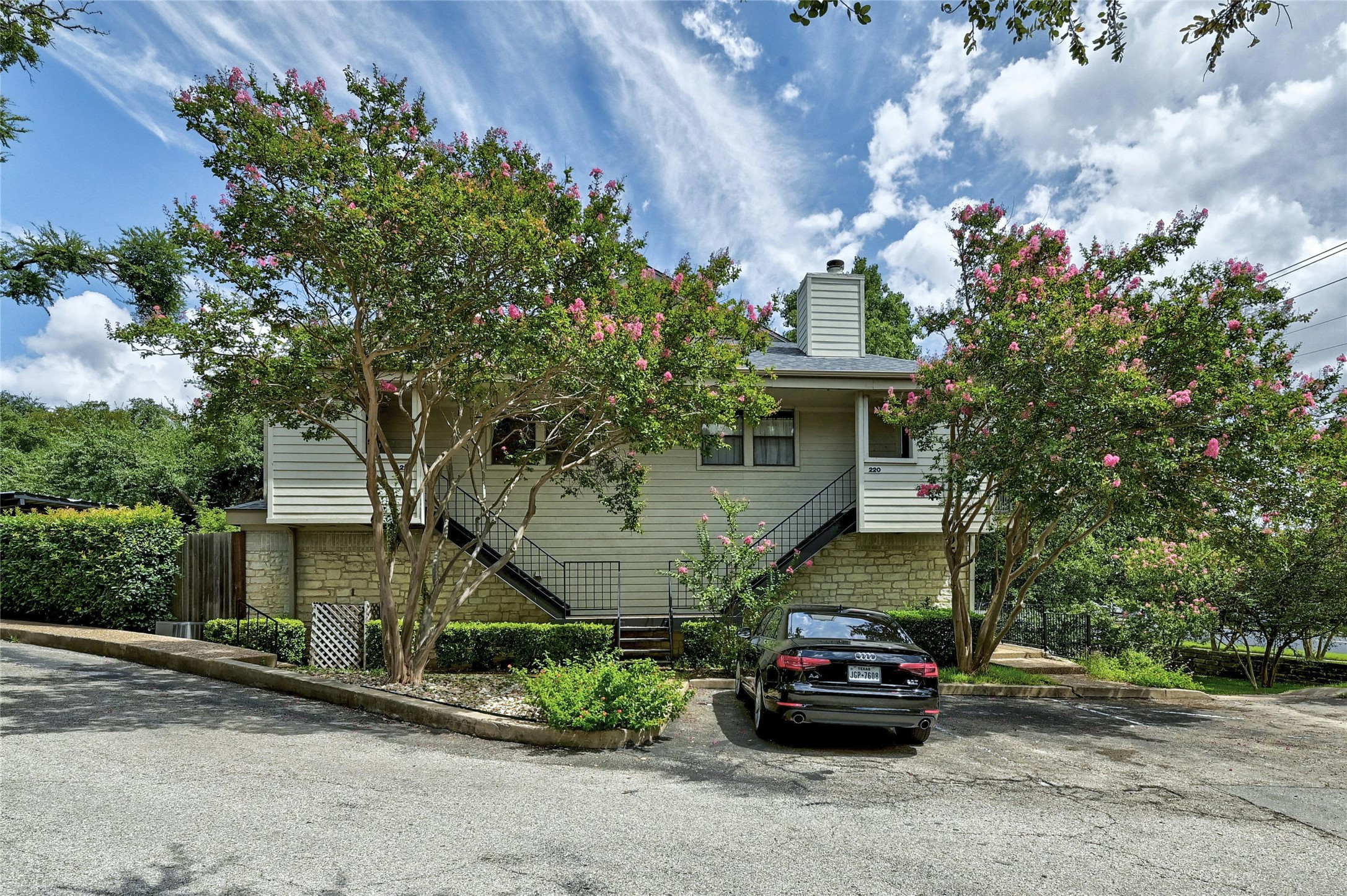 9226 Jollyville Road, Unit 221 Austin, TX 78759 - Photo 2 of 20 A welcoming front entrance features blooming trees and a private stairway leading to the residence.