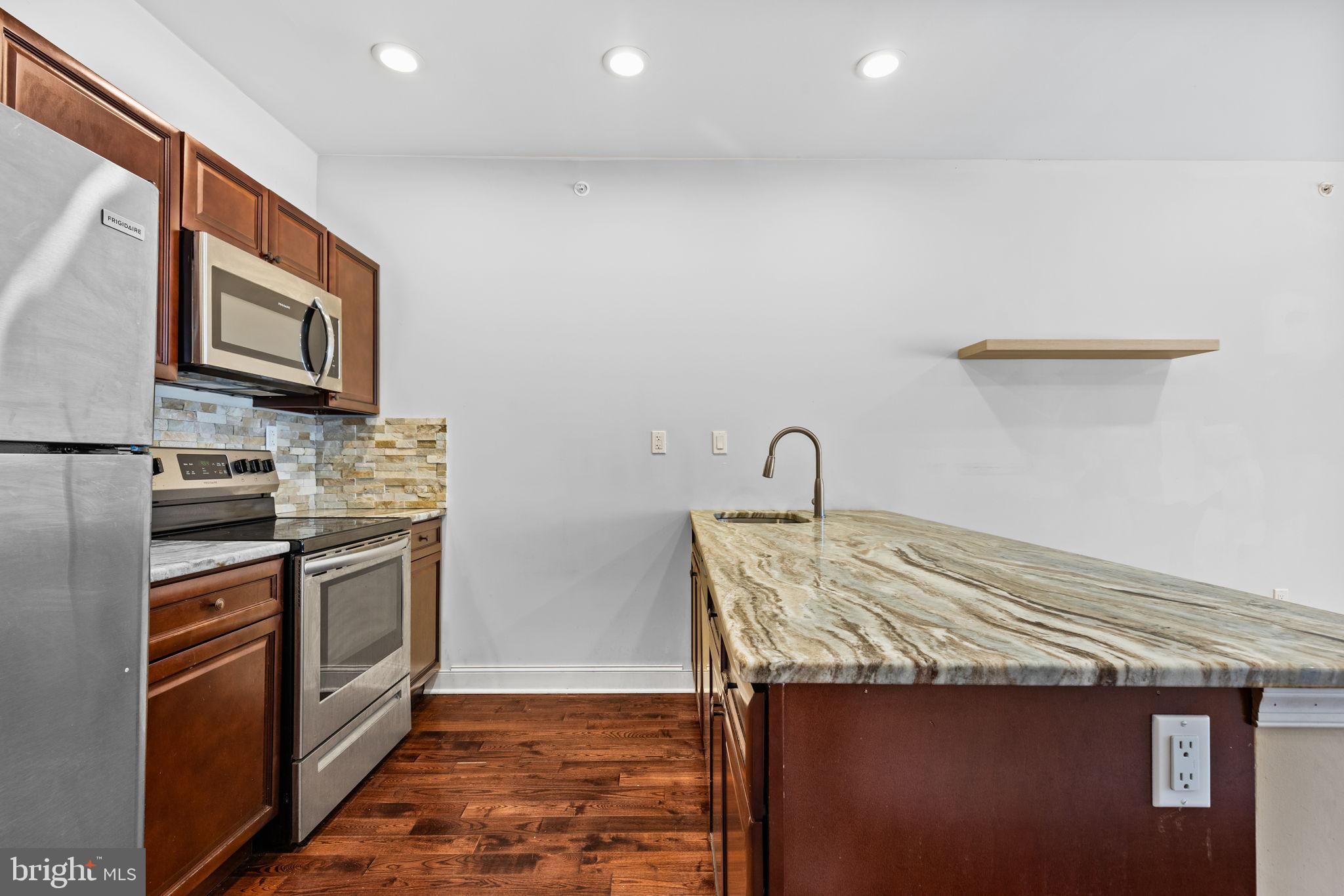 4633 Walnut Street, Unit D Philadelphia, PA 19139 - Photo 2 of 10 a kitchen with stainless steel appliances granite countertop a stove a sink and a microwave
