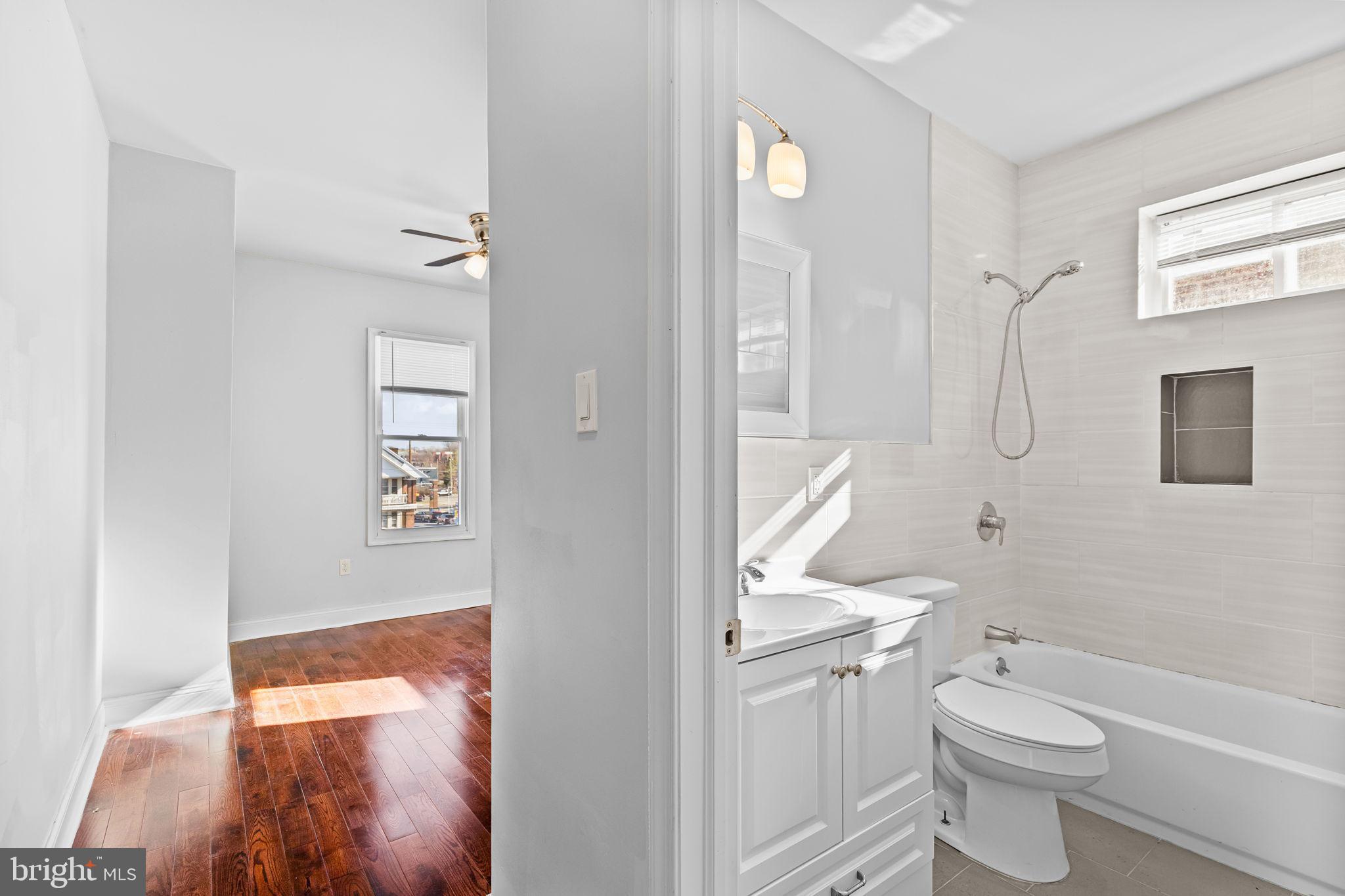 4633 Walnut Street, Unit D Philadelphia, PA 19139 - Photo 4 of 10 a bathroom with a toilet a sink and bathtub